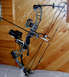 1988 Ford Bronco - A compound bow with a camera attached is displayed against a wood-paneled wall.