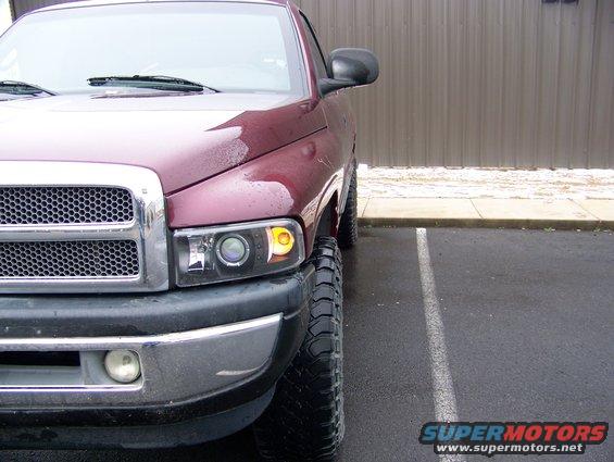 Maroon 2001 Dodge 1500 pickup truck front corner with chrome grille and aftermarket headlights