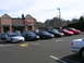 2007 Mazda 3 - Multiple Mitsubishi Eclipse models are parked in a lot outside a commercial building.