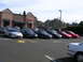 2007 Mazda 3 - A row of cars, mostly Mitsubishi Eclipses, are parked in a lot outside a restaurant.