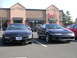 2007 Mazda 3 - Two coupes are parked in a lot in front of a building with a sign that says Capello's.