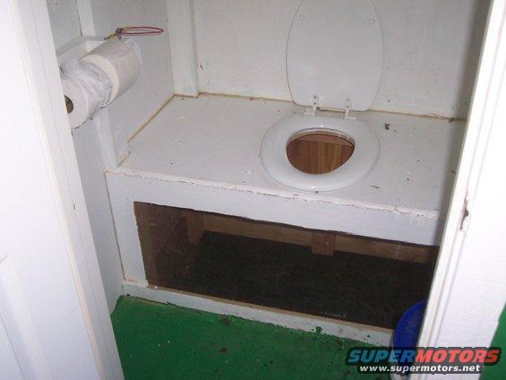 Interior toilet with open lid and roll of toilet paper