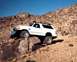 1993 Ford Ranger - This 1990s Ford Bronco is navigating a challenging off-road trail with large boulders.