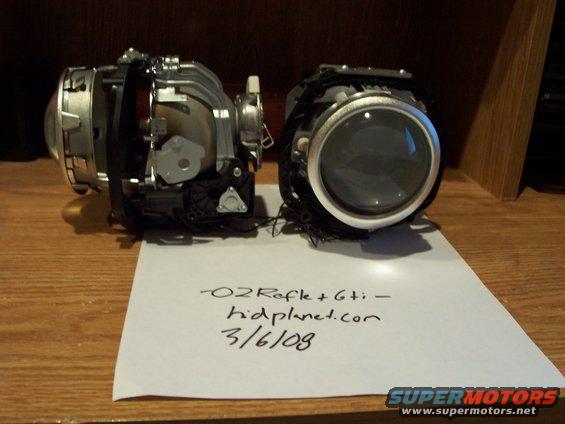 Two car headlight assemblies on a wooden surface with a handwritten note