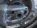2007 Yamaha YZ450F - This image shows a close-up view of the rear axle adjustment mechanism on a motorcycle, including the bolt and part of the chain.