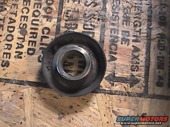 Motorcycle part with metal insert, resting on wood with text