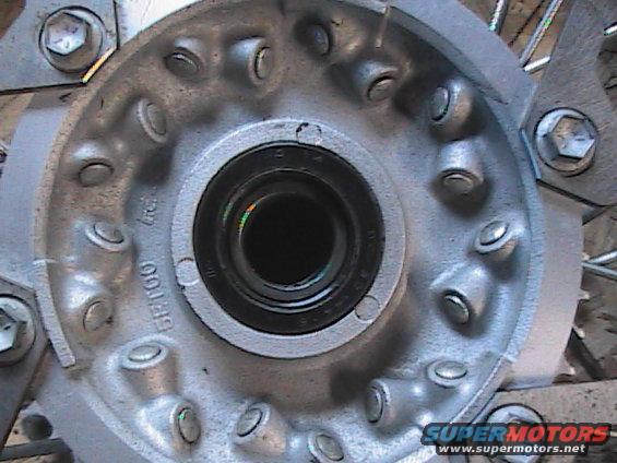 Close-up of a motorcycle wheel hub with spokes visible. Text '5F100' is stamped on the hub