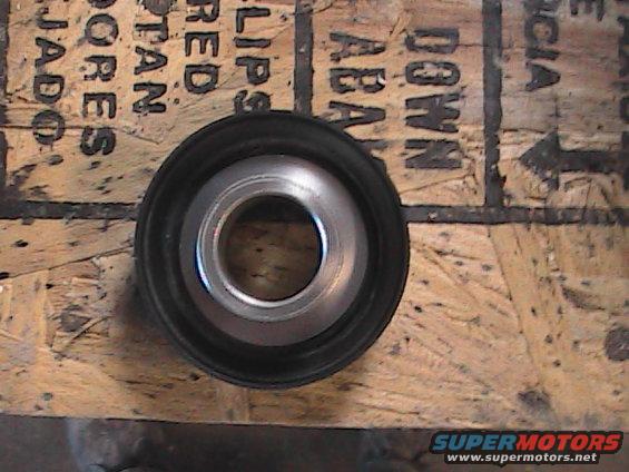 Metal bearing with black rubber seal on plywood