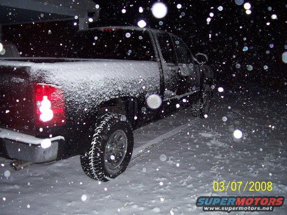 Rear view of black pickup truck in snow, 2008 date stamp visible