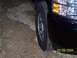 2008 Chevrolet Silverado 1500 - Close-up of a black pickup truck's front corner, showing the wheel and headlight assembly.