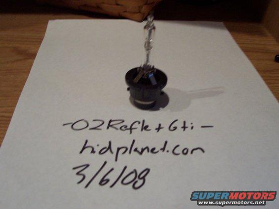 Headlight bulb on paper with handwritten text '-02Refle+Gti - hidplanet.com 3/6/09'