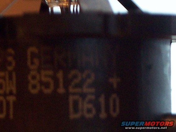 Close-up of a dark part with yellow text that reads '5 G 85122 + D610'