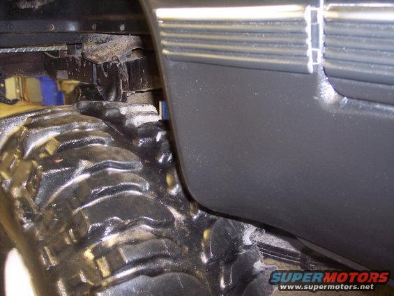 Close-up of a large off-road tire and the lower fender area of a truck