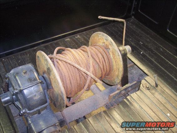 Winch with coiled rope in truck bed, Supermotors.net logo visible