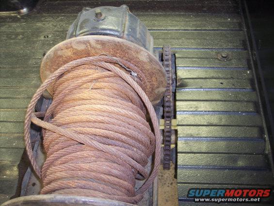 winch with rusty cable coiled on it, mounted on a truck bed