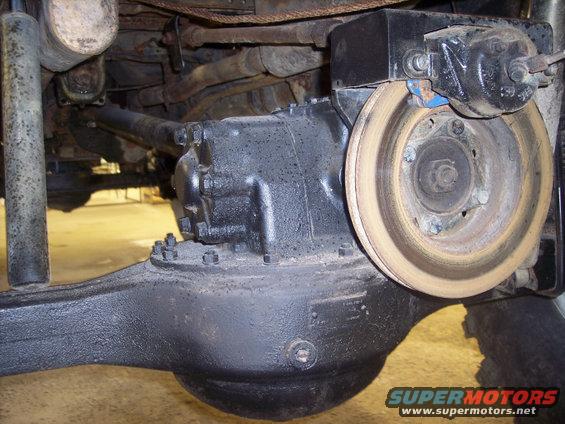 Close-up of a vehicle's rear axle housing, differential, and brake rotor