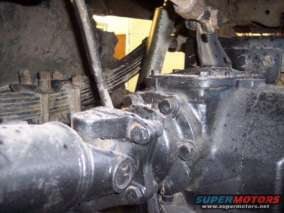 Close-up of a vehicle's rear axle, differential housing, driveshaft, and leaf springs