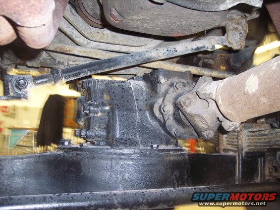 Underside view of vehicle drivetrain components, including a transfer case and driveshaft