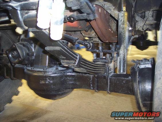 Black painted truck rear axle assembly with leaf springs and shock absorber
