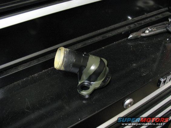 Black and green striped automotive coolant elbow part with a white rimmed opening