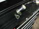 1997 Ford Crown Victoria - A coolant elbow part sits on a black toolbox with tools in the background.