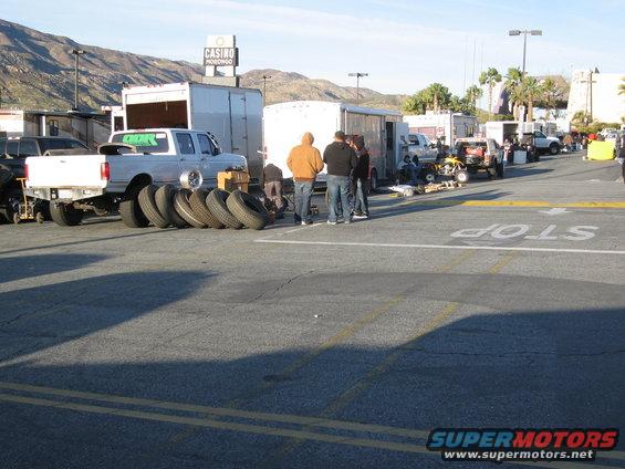 Ford F-Series truck with tires lined up, parked near trailers and other vehicles