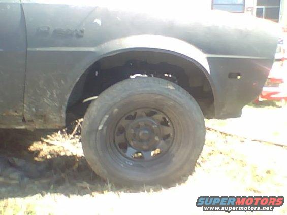 1981 Dodge Power Ram fender and wheel, dark color, muddy, side view