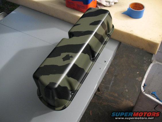 Camouflaged valve cover on a workbench