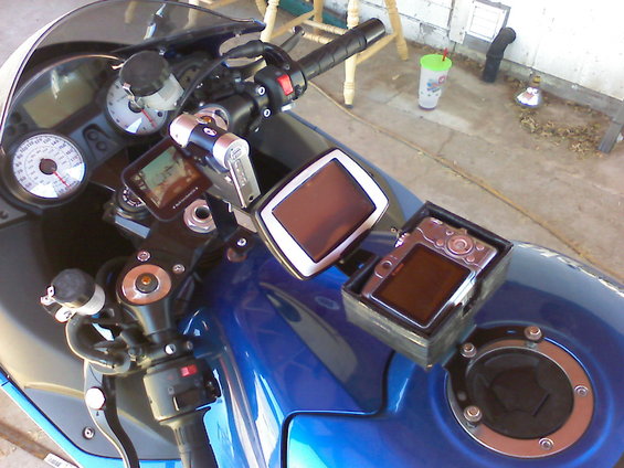 Motorcycle dashboard showing GPS unit, digital camera, and gauges