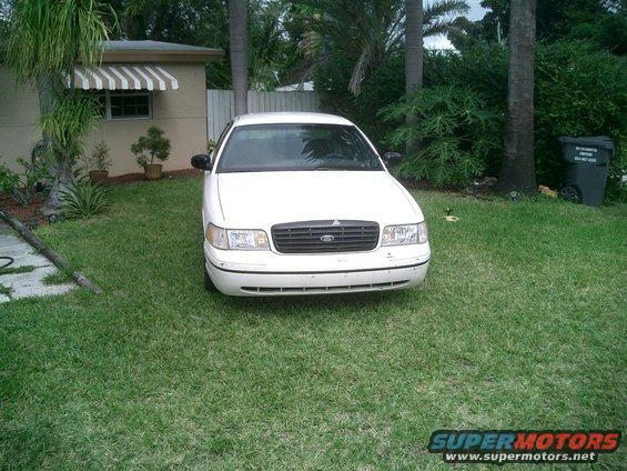 Front view of a white 1998 Ford Crown Victoria parked in a yard