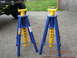 2008 Ford F-450 - Two heavy-duty jack stands are positioned on a paved surface, with a portion of a vehicle visible in the background.