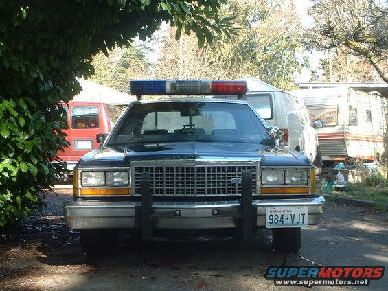 1987 Ford Crown Victoria LTD police car front view, dark blue, with push bumper and light bar