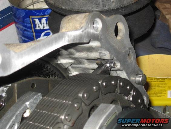 Close-up of engine timing chain and gears with metal bracket