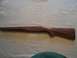 1991 Ford Bronco - A wooden rifle stock is shown against a white fabric surface.