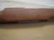 1991 Ford Bronco - A close-up view of a wooden gun stock, revealing a recessed section with layered material visible within.