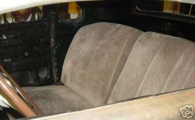 Interior view of tan seats and brown steering wheel in a classic car
