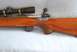 1991 Ford Bronco - A rifle with a wooden stock and a scope is shown from the side.