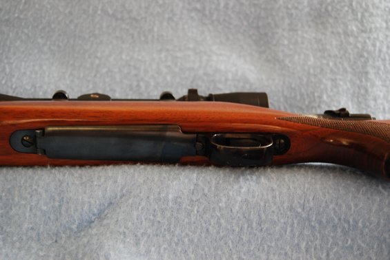 Side view of rifle action with scope and wooden stock