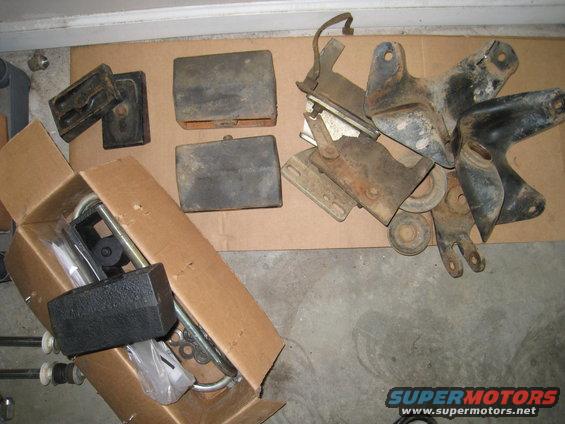 Pile of assorted vehicle parts including brackets and rubber blocks