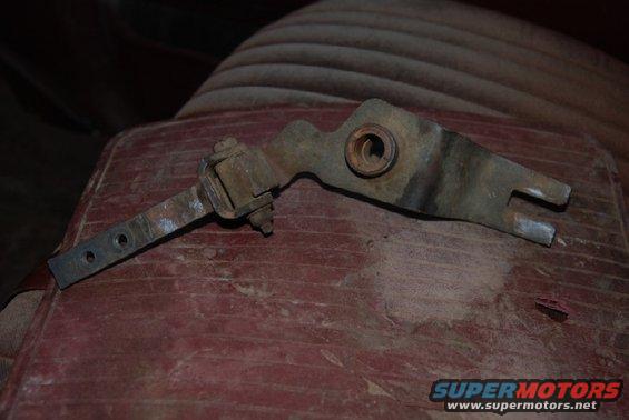 Rusted transfer case shifter linkage part on red textured surface