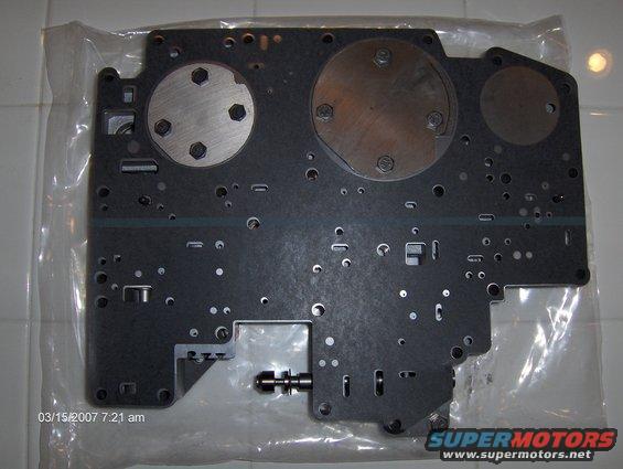 valve body plate with circular metal inserts and many small holes