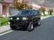 1991 Ford Bronco - A black SUV with a lifted suspension and aggressive tires is parked on a residential street.