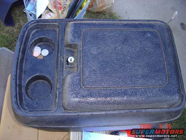 Black center console with two cup holders and a lock mechanism