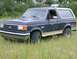 1990 Ford Bronco - This 1990 Ford Bronco is parked in a grassy field, showing its side and front quarter view.