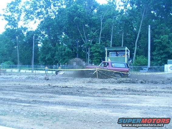 red SUV driving through mud pit