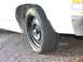 1985 Ford Crown Victoria LTD - Close-up of a white car's wheel a steel rim and "TOURING SLC" tire branding.