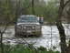 1996 Ford Bronco - Ford F-250 Super Duty navigates through a flooded area, with two onlookers present.