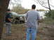 1996 Ford Bronco - A black Ford Bronco is stuck in muddy water with two men observing.