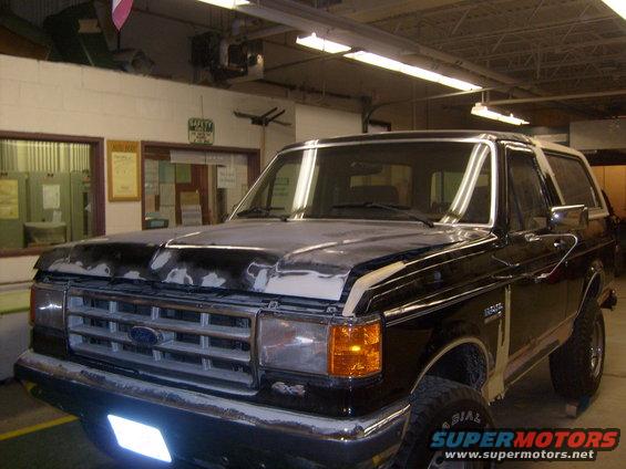 1987 Ford Bronco in black with white top, undergoing bodywork, front 3/4 view