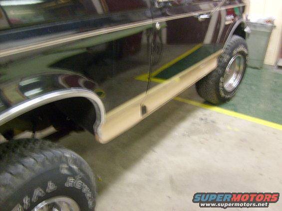Dark brown Ford Bronco side view, showing woodgrain trim and chrome fender trim